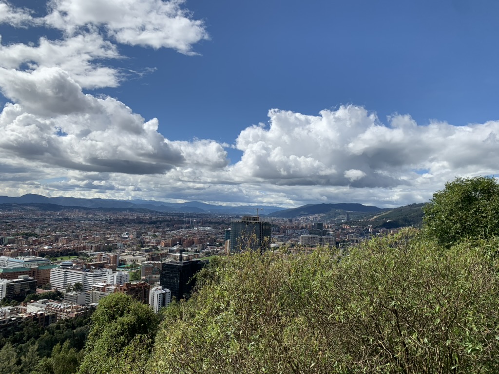 Bogotá seen across green hills beneath a wide blue sky